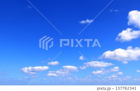 White clouds in the blue sky. Beautiful nature landscape. The azure expanse of the sky is adorned with pristine white clouds, creating a picturesque natural scene White clouds in the blue sky. Beautiful nature landscape. The azure expanse of the sky is adorned with pristine white clouds, creating a picturesque natural scene 137762341