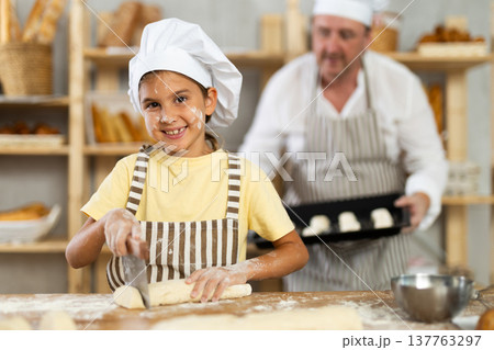 Dad and daughter cook croissants together, cut dough and have nice time Dad and daughter cook croissants together, cut dough and have nice time 137763297