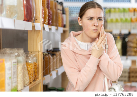 woman felt a toothache in a store 137763299