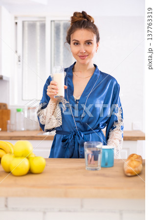Positive woman drinking dairy product at home 137763319