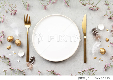 Minimal Easter Table Setting with Golden Eggs and Spring Flowers 137763549