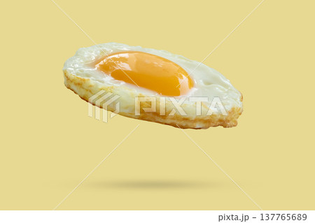 Fried egg float on yellow background Fried egg float on yellow background 137765689