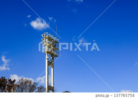 Stadium lights against blue sky, daytime. 137765758