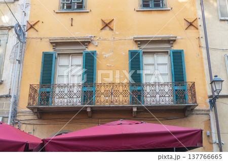 Traditional Italian residential building in historic town center. Classic Mediterranean architecture reflecting local lifestyle and cultural identity. Traditional Italian residential building in historic town center. Classic Mediterranean architecture reflecting local lifestyle and cultural identity. 137766665
