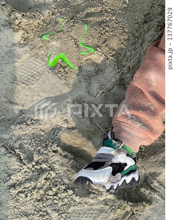 Child sneaker in beach sand with toy shovel Child sneaker in beach sand with toy shovel 137767029