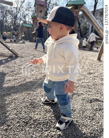 Toddler in white hoodie at playground on sunny day Toddler in white hoodie at playground on sunny day 137767054