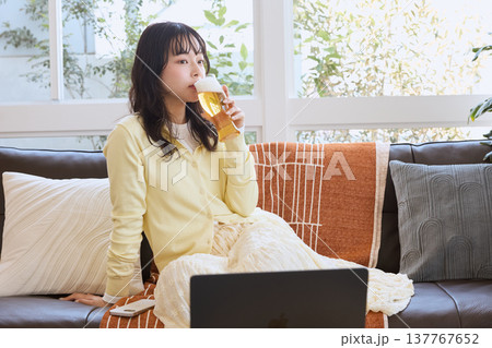 自宅でビールを楽しむ若い女性 自宅でビールを楽しむ若い女性 137767652