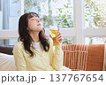 休日にビールを飲んでくつろぐ若い女性 137767654