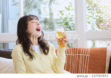 ビールを飲んでくつろぐ若い女性のライフスタイル 137767655