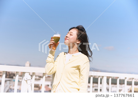青空の下でビールを楽しむ若い女性 青空の下でビールを楽しむ若い女性 137767661