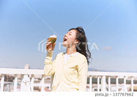 青空の下でビールを楽しむ若い女性 青空の下でビールを楽しむ若い女性 137767662