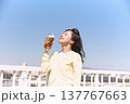 青空の下でビールを楽しむ若い女性 137767663