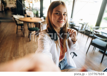 Making a selfie. Young woman is in the cafe at daytime 137767684