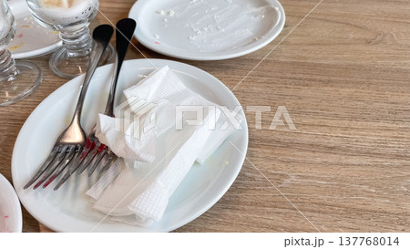Close-up of dirty dishes and used napkins on a wooden table with copy space for text after breakfast 137768014