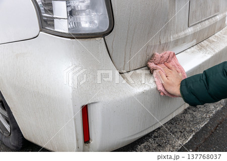汚れた車のボディーを雑巾で水拭きしている 汚れた車のボディーを雑巾で水拭きしている 137768037
