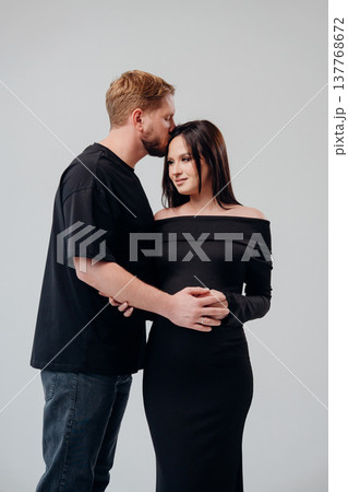 Couple embracing in stylish black attire indoors Couple embracing in stylish black attire indoors 137768672