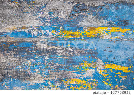 Peeling paint on the concrete wall with old cracked flaking paint. Weathered rough painted surface 137768932