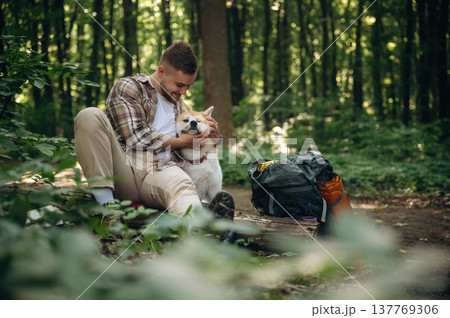 Rural, non urban scene, sitting, resting. Man tourist is with his dog in the forest 137769306