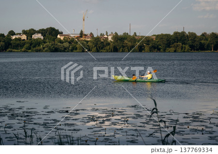 Sportive father is with his young son is swimming in the kayak Sportive father is with his young son is swimming in the kayak 137769334