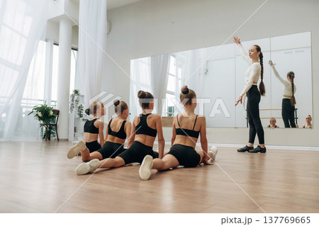 Daily practice routine. Trainer is teaching girls ballet dancing Daily practice routine. Trainer is teaching girls ballet dancing 137769665