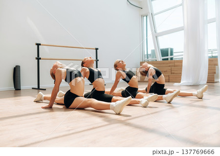 On the floor. Girls practicing ballet indoors in the class On the floor. Girls practicing ballet indoors in the class 137769666