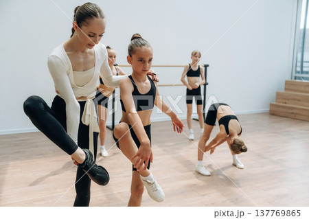 Helping, rehearsal process. Trainer is teaching girls ballet dancing 137769865