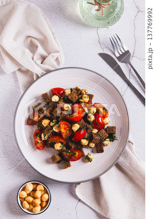 A mixture of tomatoes, cheese and rye croutons on a plate on the table top and vertical view A mixture of tomatoes, cheese and rye croutons on a plate on the table top and vertical view 137769992
