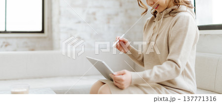 ソファでタブレットに向かう女性 ソファでタブレットに向かう女性 137771316