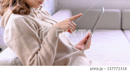 ソファでタブレットを操作する女性 ソファでタブレットを操作する女性 137771318
