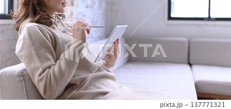 タブレットで作業する女性のクローズアップ タブレットで作業する女性のクローズアップ 137771321