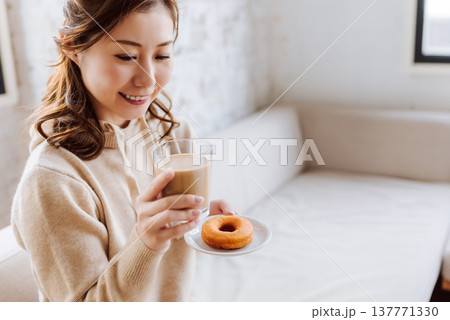 ドーナツとカフェラテを持つ女性 137771330