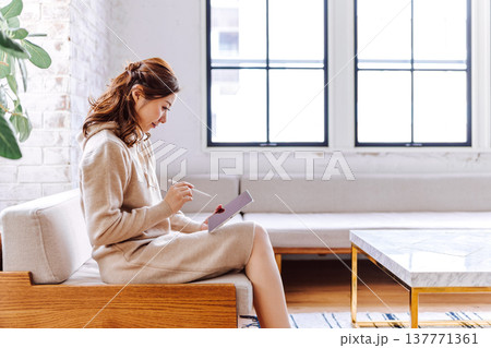 ソファでタブレットに描画する女性 ソファでタブレットに描画する女性 137771361