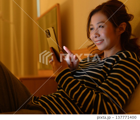 ベッドでスマホを操作する女性 137771400