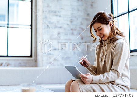 タブレットで作業するクリエイティブな女性 タブレットで作業するクリエイティブな女性 137771403