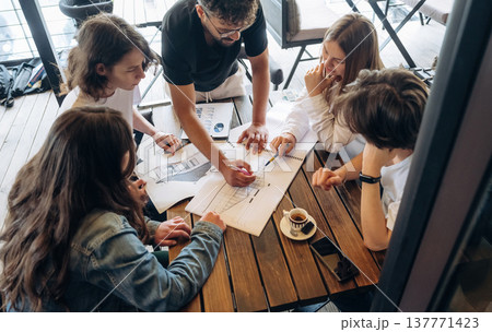 Job with documents in progress, start up. Group of young friends are in the cafe restaurant Job with documents in progress, start up. Group of young friends are in the cafe restaurant 137771423