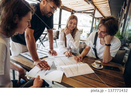 Cool start up, working on the project. Group of young friends are in the cafe restaurant Cool start up, working on the project. Group of young friends are in the cafe restaurant 137771432