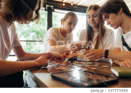 Relaxing by playing card game. Group of young friends are in the cafe restaurant 137771450