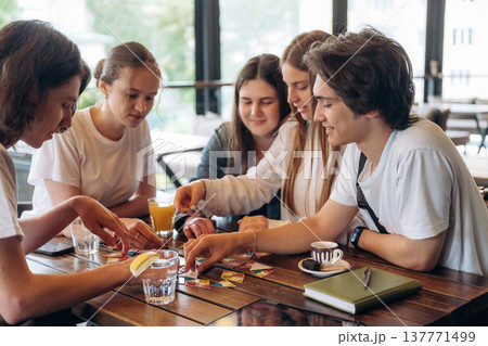 Wellness, playing card game. Group of young friends are in the cafe restaurant 137771499