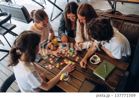 View from the top, playing game. Group of young friends are in the cafe restaurant View from the top, playing game. Group of young friends are in the cafe restaurant 137771509