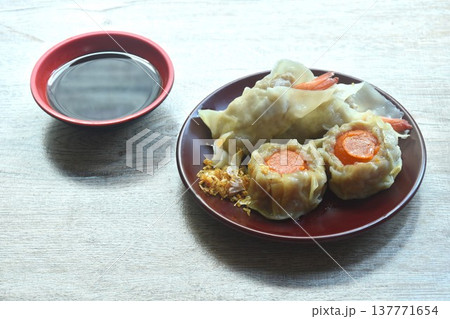 steamed Chinese dumpling stuffing shrimp and chop pork with salty egg on plate dipping soy sauce 137771654