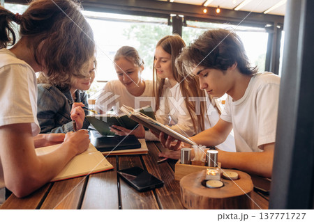 Reading, education concept. Group of young friends are in the cafe restaurant Reading, education concept. Group of young friends are in the cafe restaurant 137771727