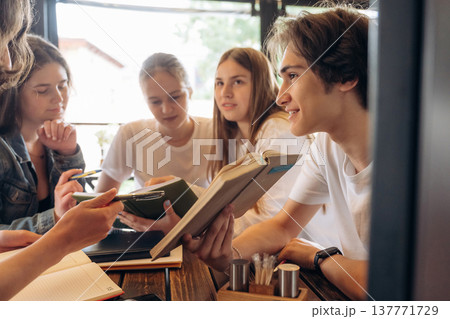Reading, education concept. Group of young friends are in the cafe restaurant Reading, education concept. Group of young friends are in the cafe restaurant 137771729