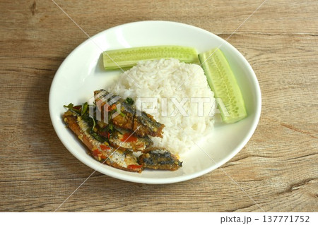 spicy stir fried mackerel with basil and fresh chili on plain rice eat couple slice cucumber on dish spicy stir fried mackerel with basil and fresh chili on plain rice eat couple slice cucumber on dish 137771752