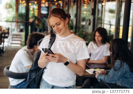 Girl is with phone. Group of young friends are in the cafe restaurant Girl is with phone. Group of young friends are in the cafe restaurant 137771775