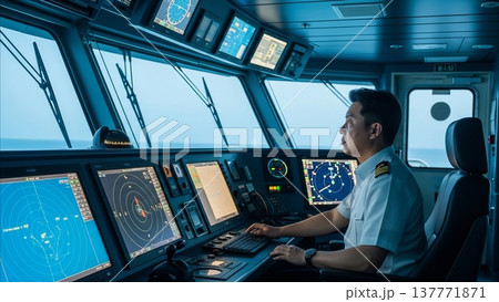 Asian naval officer operating radar navigation system on modern warship bridge with multiple digital displays and maritime control equipment 137771871