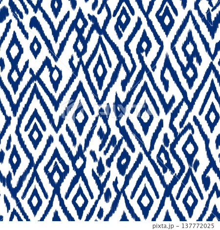 Seamless ikat geometric pattern creating textile design. Traditional blue chevron ikat pattern forming a seamless repeating background texture 137772025