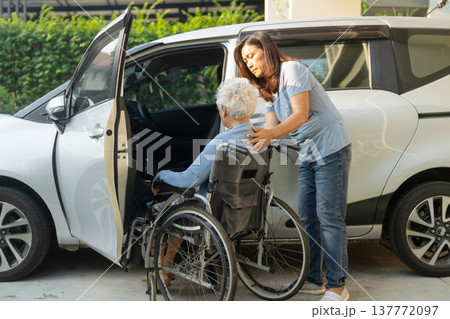 Caregiver help Asian elderly woman disability patient get into car. 137772097