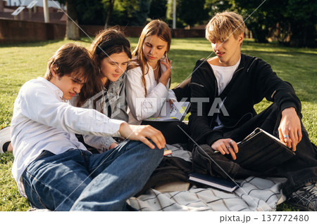 Reading together. Friends students are outdoors 137772480