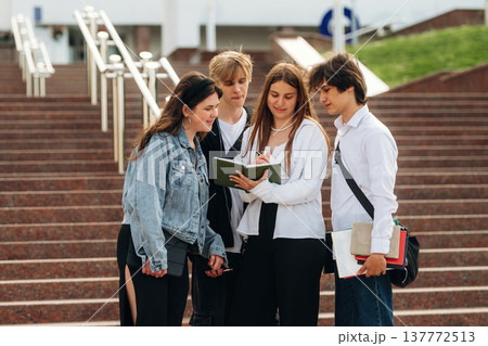 White building behind, people on the stairs. Group of students are near university together White building behind, people on the stairs. Group of students are near university together 137772513