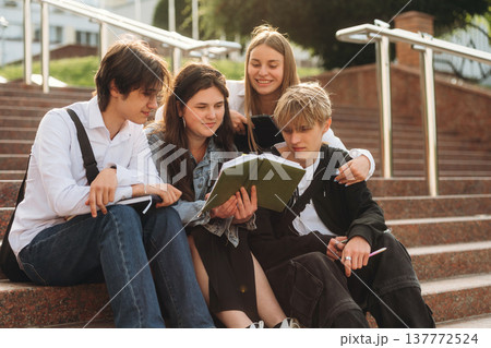 Under sunlight, sitting. Group of students are near university together 137772524